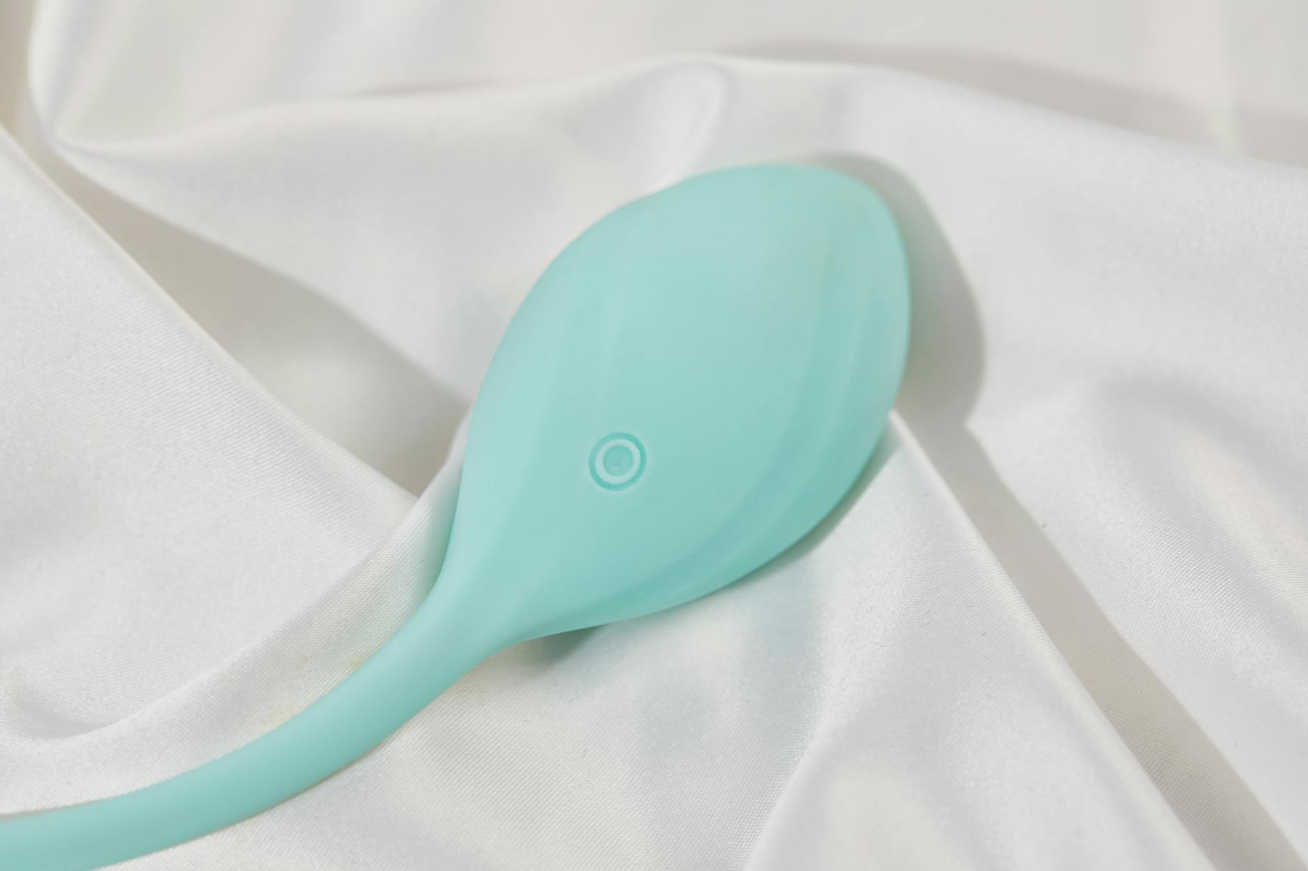 Hand holding an orange vibrator against a minimalist purple backdrop, symbolizing self-exploration and modern intimacy
