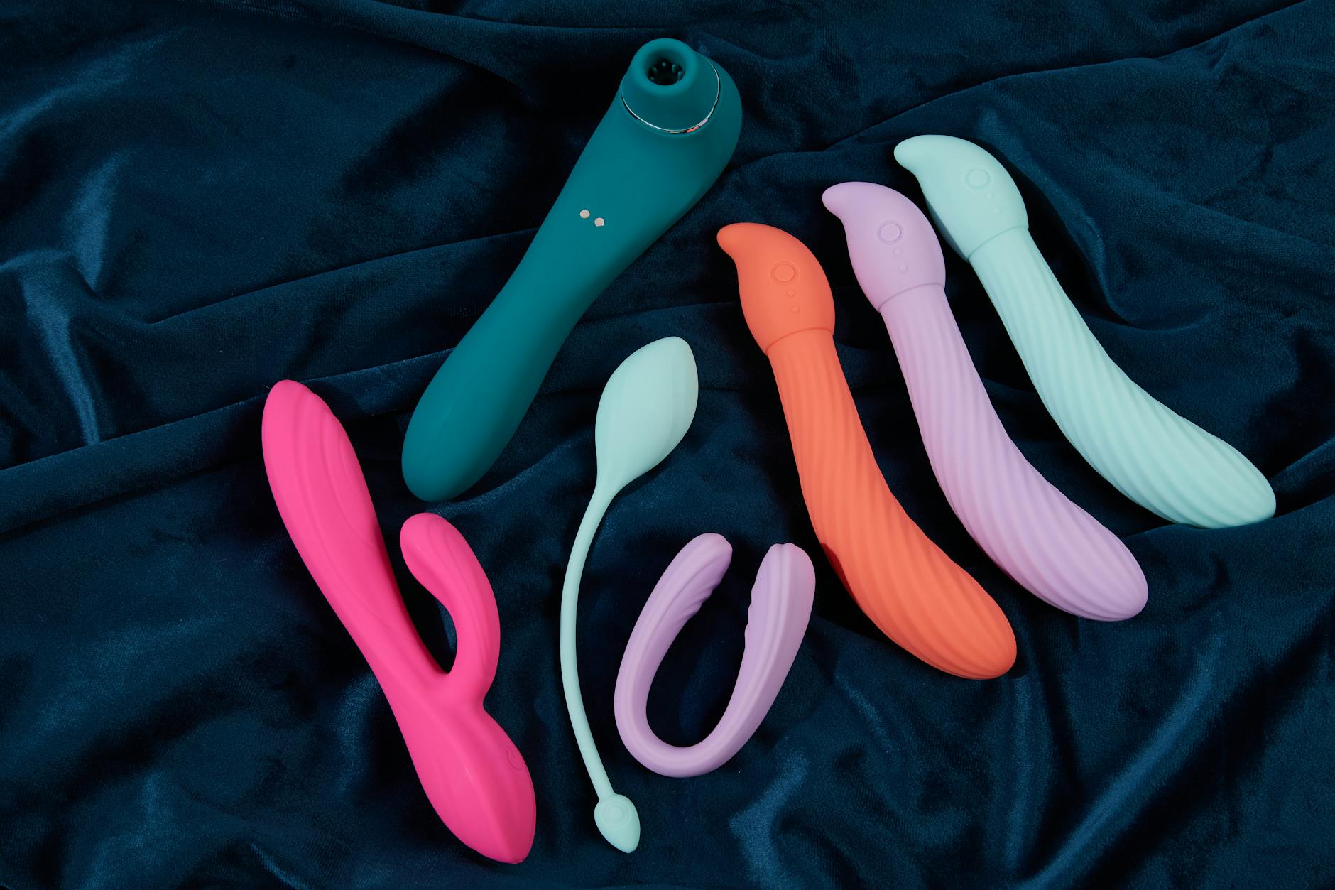Woman holding two silicone vibrators thoughtfully, representing openness to couples exploration