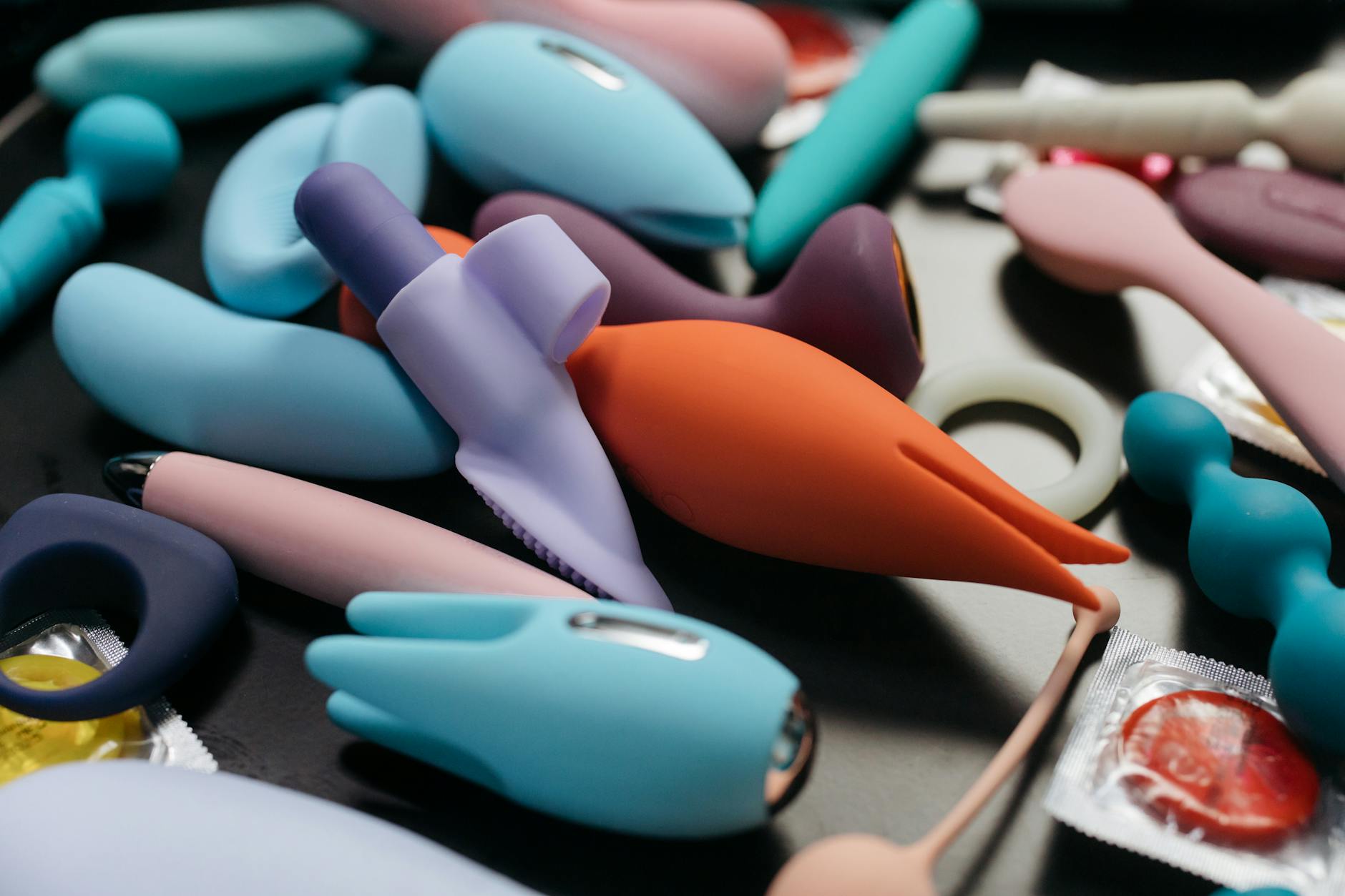 A hand holding a modern vibrator against a purple backdrop, symbolizing intimate exploration with curiosity and openness.