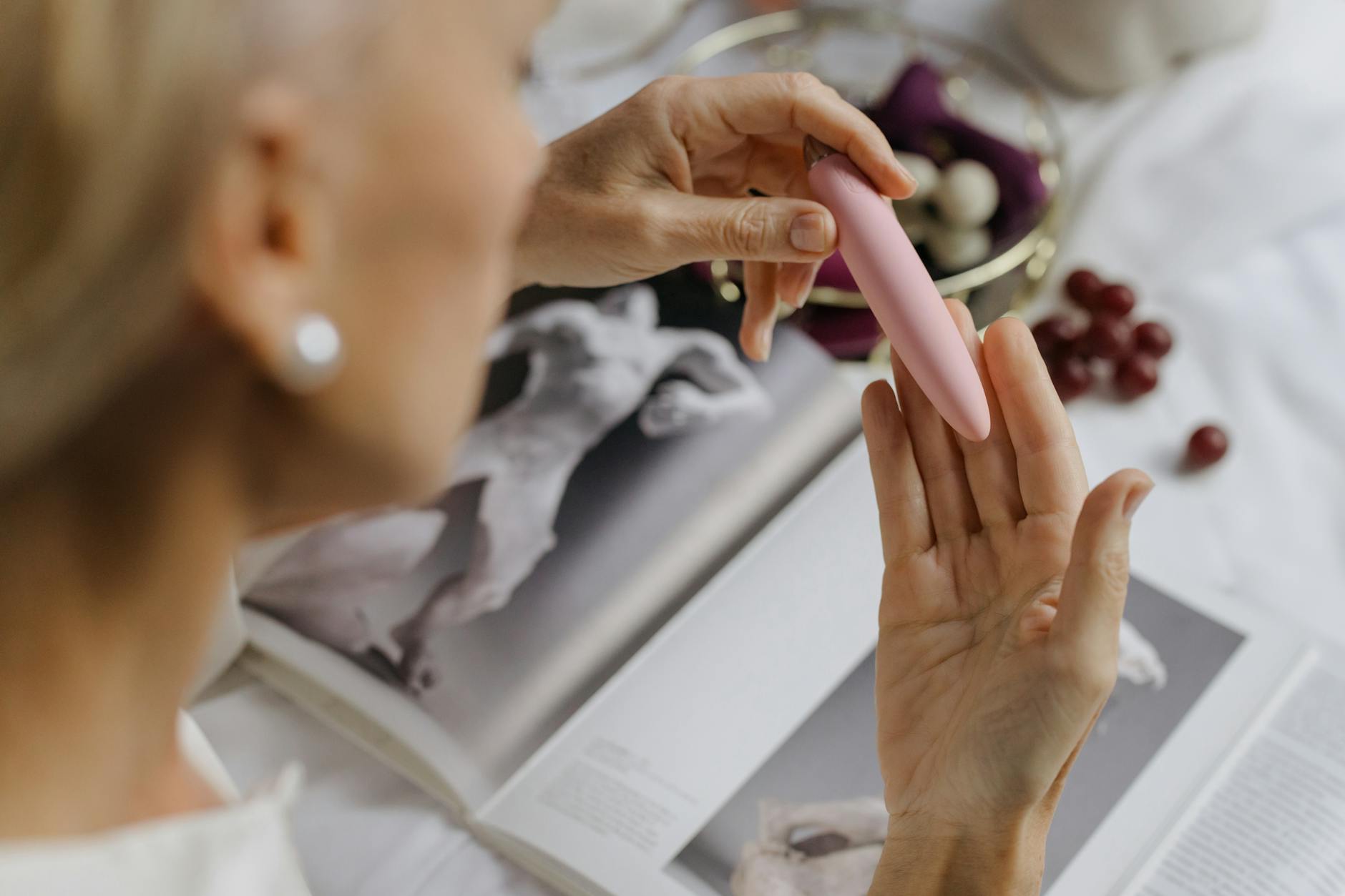 Woman holding a pink personal vibrator, emphasizing personal pleasure and self-connection.
